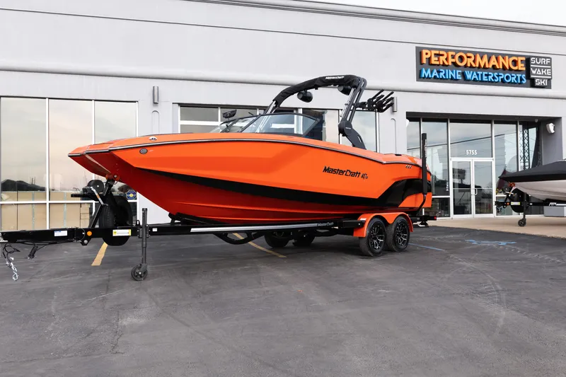 The Image of 2026 MasterCraft NXT24 boat in vibrant orange at Performance Marine Watersports dealership. - 1