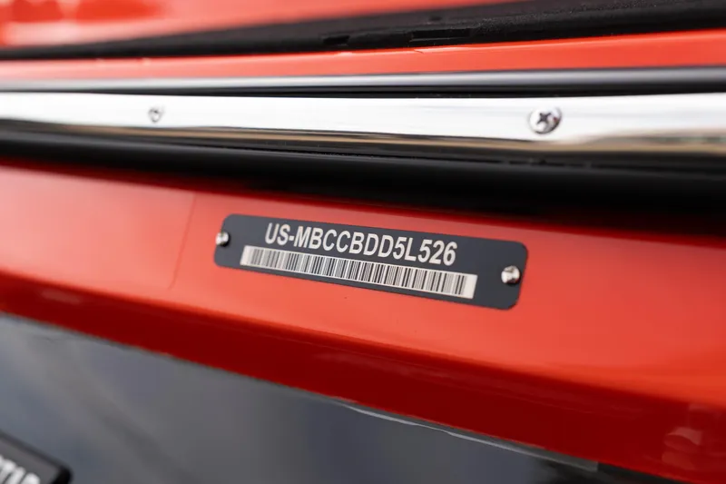 Slide: The Image of 2026 MasterCraft NXT24 boat identification plate with serial number on orange hull. - 11