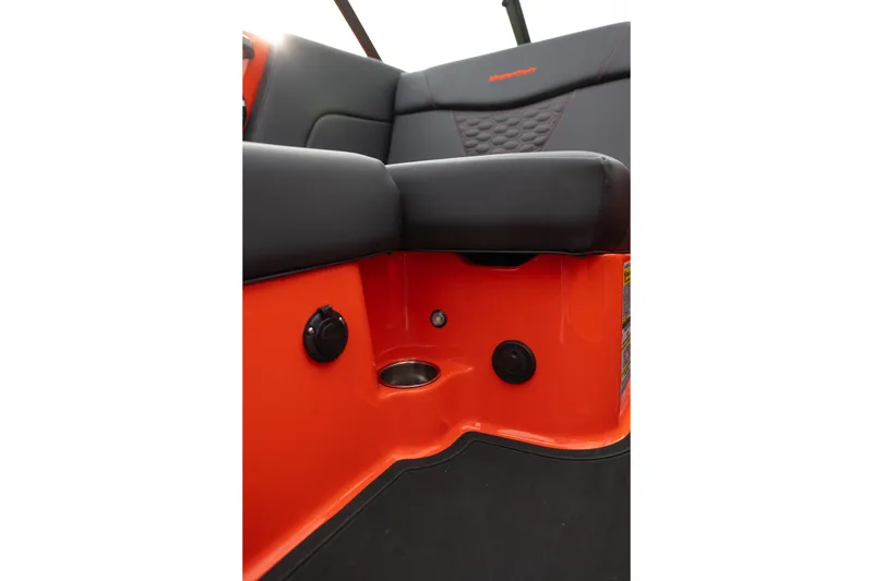 Slide: The Image of 2026 MasterCraft NXT24 interior detail with orange and black seating and cup holder. - 24