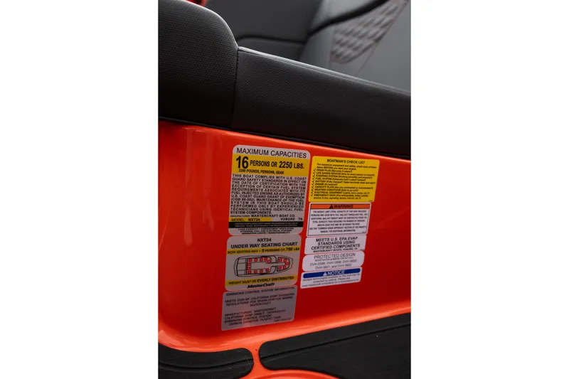 Slide: The Image of 2026 MasterCraft NXT24 capacity label, seating chart, and safety warnings on orange interior. - 27
