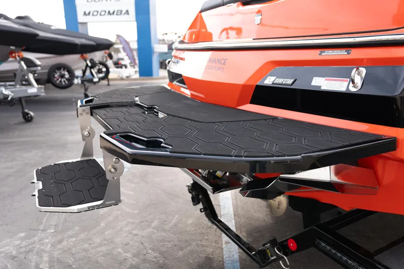 Slide: The Image of 2026 MasterCraft NXT24 boat with orange exterior and black swim platform. - 7