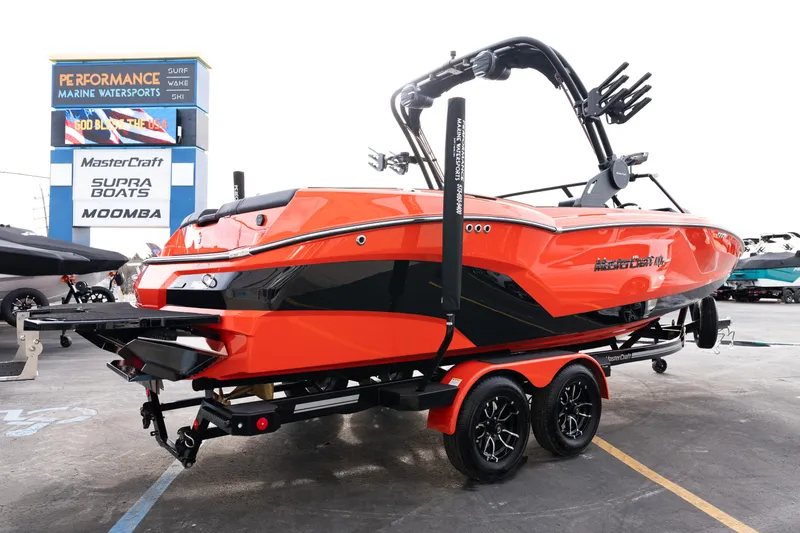 Slide: The Image of 2026 MasterCraft NXT24 boat in vibrant orange on a trailer at a dealership. - 9