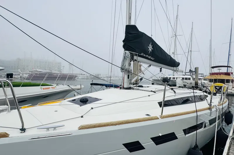 Slide: The Image of 2024 Jeanneau Sun Odyssey 349 sailboat docked in a marina, showcasing sleek design. - 13