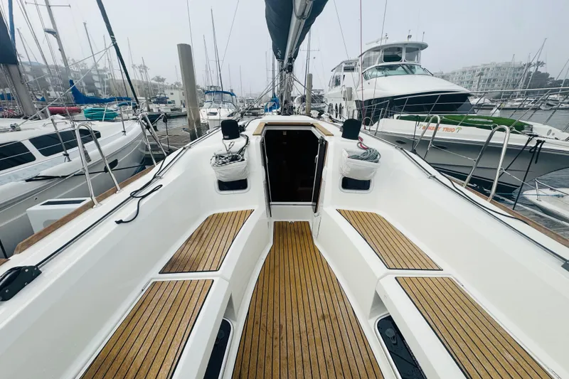 Slide: The Image of 2024 Jeanneau Sun Odyssey 349 sailboat cockpit with teak flooring and marina view. - 20