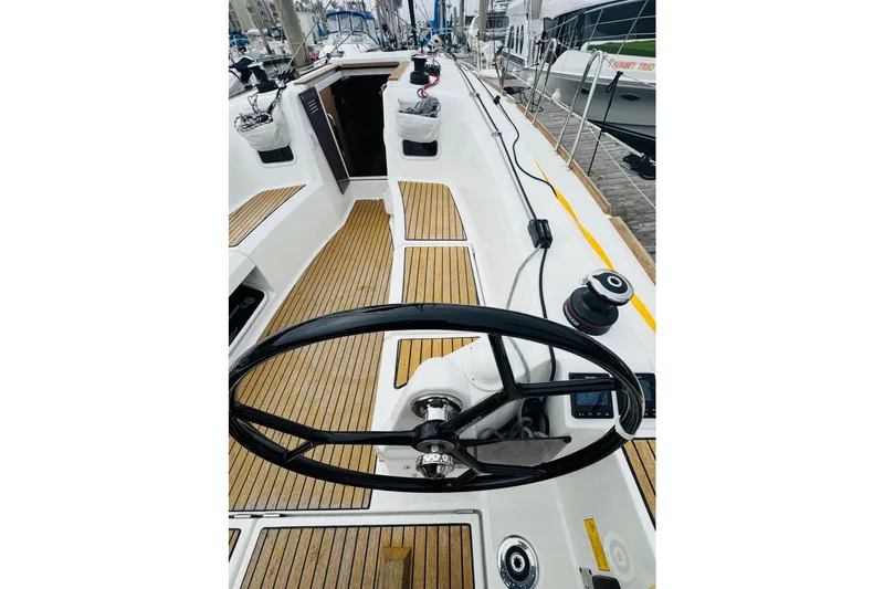 Slide: The Image of 2024 Jeanneau Sun Odyssey 349 sailboat cockpit with wooden deck and steering wheel. - 23