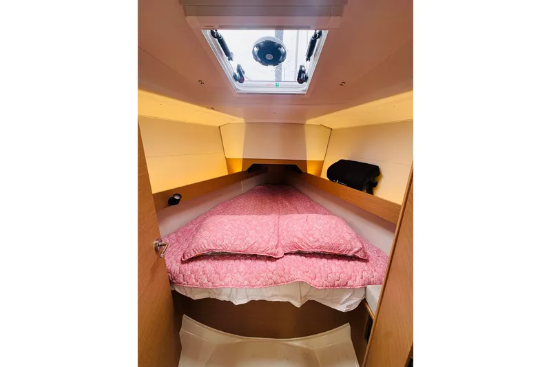 Slide: The Image of 2024 Jeanneau Sun Odyssey 349 cabin with floral bedding and wooden cabinetry. - 53