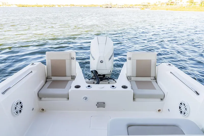 Slide: The Image of 2026 Boston Whaler 210 Vantage boat interior with seating and windshield, parked outdoors. - 14