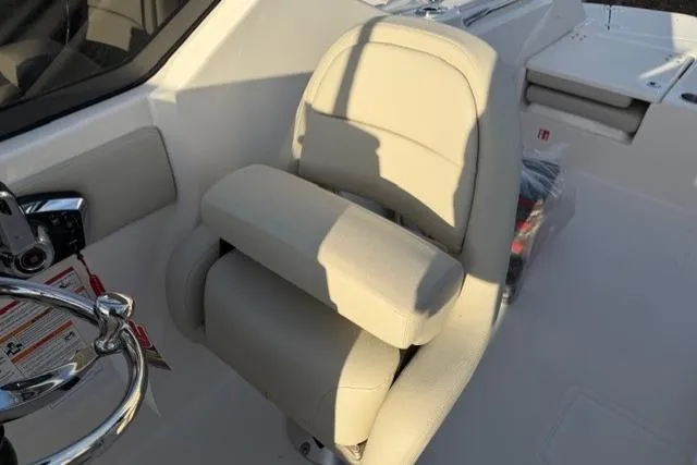 Slide: The Image of 2026 Boston Whaler 210 Vantage boat interior with beige captain's chair and steering wheel. - 23