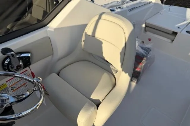 Slide: The Image of 2026 Boston Whaler 210 Vantage boat interior with steering wheel and beige captain's seat. - 24