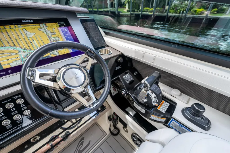 Slide: The Image of 2019 Sea Ray SLX 400 Outboard helm with steering wheel and navigation display. - 15