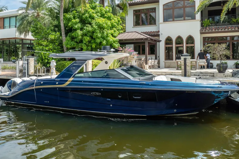 Slide: The Image of 2019 Sea Ray SLX 400 Outboard boat docked by a luxurious waterfront home. - 2