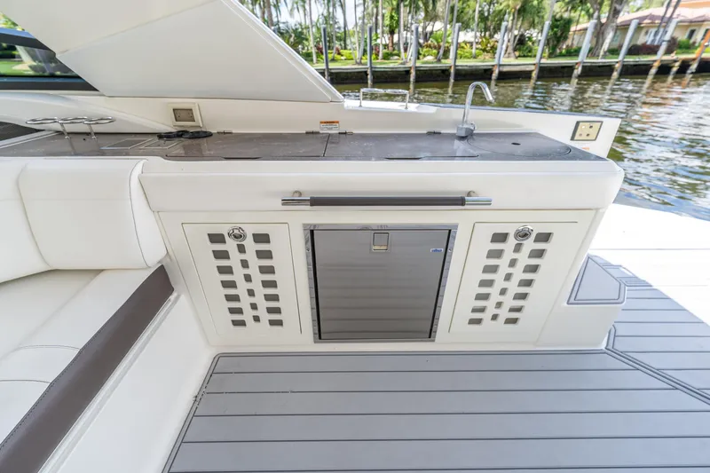 Slide: The Image of 2019 Sea Ray SLX 400 Outboard boat kitchen area with sink and storage. - 28