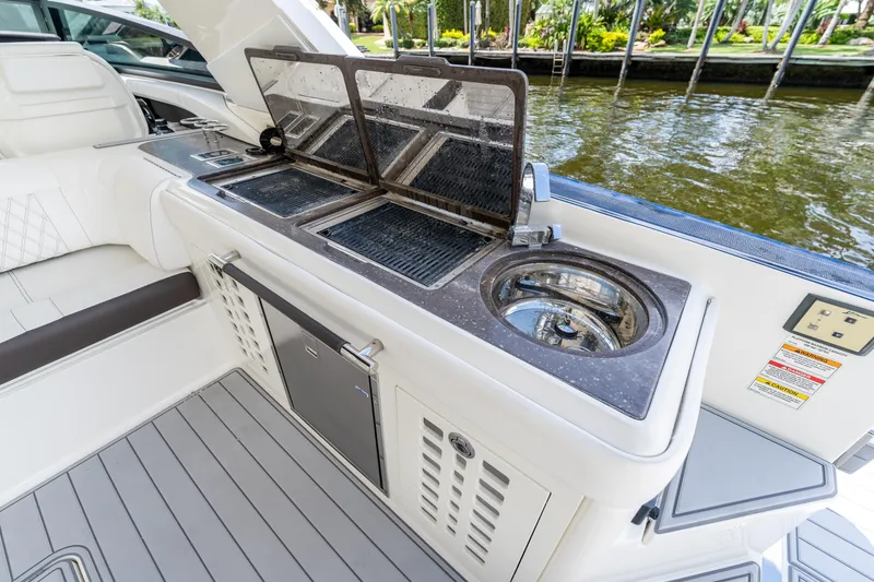 Slide: The Image of 2019 Sea Ray SLX 400 Outboard boat with outdoor kitchen and grill setup. - 29