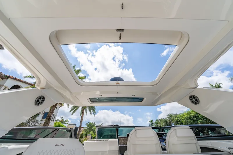 Slide: The Image of 2019 Sea Ray SLX 400 Outboard boat interior with open sunroof and clear sky view. - 41