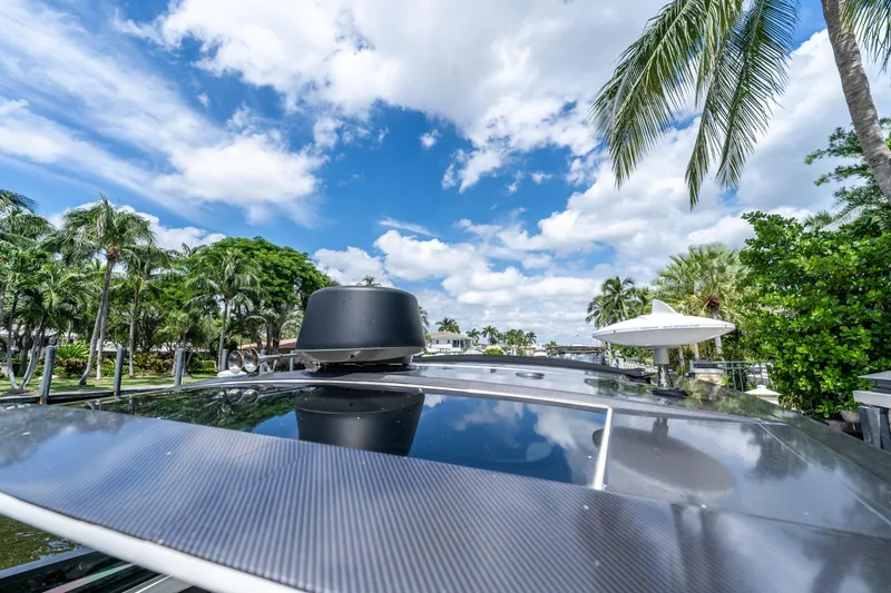 Slide: The Image of 2019 Sea Ray SLX 400 Outboard boat under a vibrant blue sky with palm trees. - 46