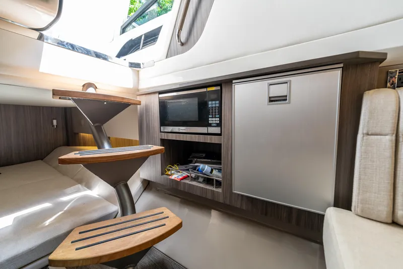 Slide: The Image of 2019 Sea Ray SLX 400 Outboard cabin interior with stairs, microwave, and storage. - 50