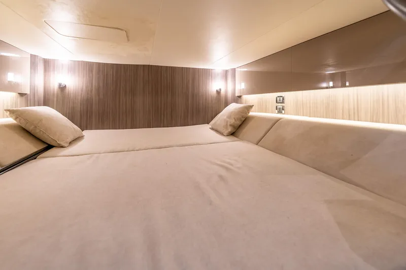 Slide: The Image of Luxurious cabin interior of 2019 Sea Ray SLX 400 Outboard, featuring cozy bedding and ambient lighting. - 56