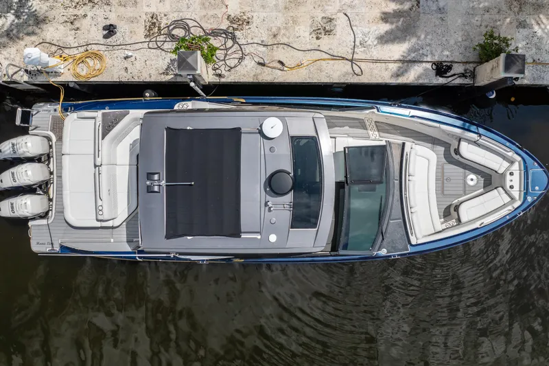 Slide: The Image of Overhead view of 2019 Sea Ray SLX 400 Outboard docked, showcasing spacious seating and triple engines. - 6