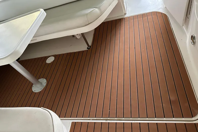 Slide: The Image of 1999 Sea Ray 340 Sundancer interior with wood-patterned flooring and white seating. - 18