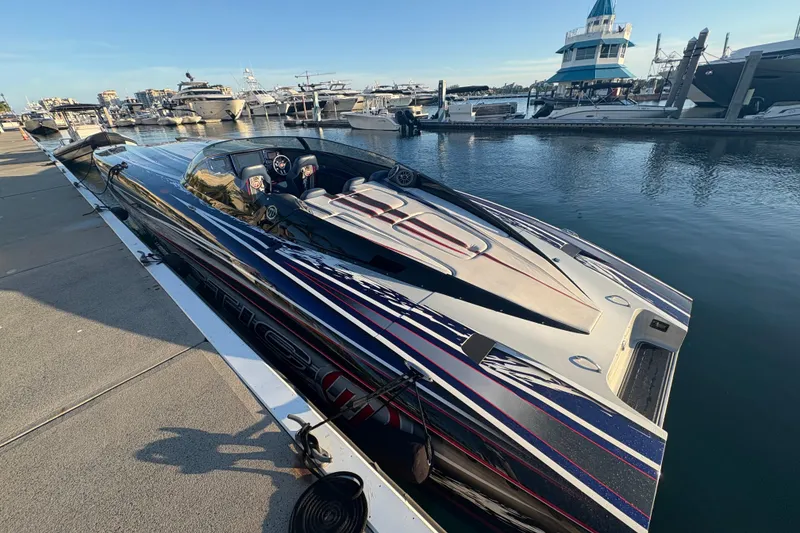 Slide: The Image of 2018 Mystic Powerboats C4400 docked at marina, sleek design with vibrant graphics. - 10
