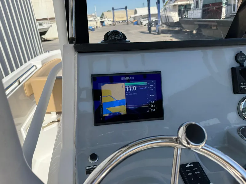 Slide: The Image of 2023 Bayliner Trophy T24CC boat cockpit with steering wheel and controls. - 11