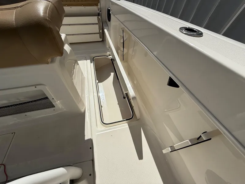Slide: The Image of 2023 Bayliner Trophy T24CC boat with tan seating, docked in a marina. - 16