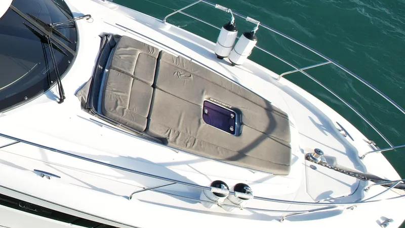 Slide: The Image of Prestige 50 Flybridge 2014 yacht deck with sunpad and railing, on calm water. - 11