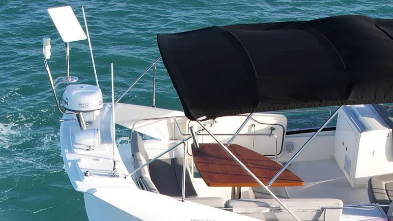 Slide: The Image of Prestige 50 Flybridge 2014 yacht with black canopy and wooden table on blue water. - 20