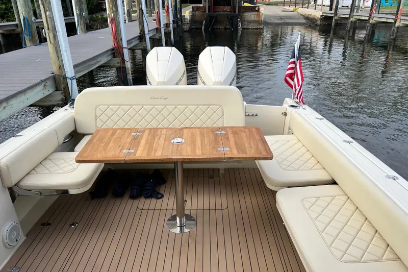 Slide: The Image of 2023 Chris-Craft Calypso 30 boat interior with seating, table, and American flag. - 10