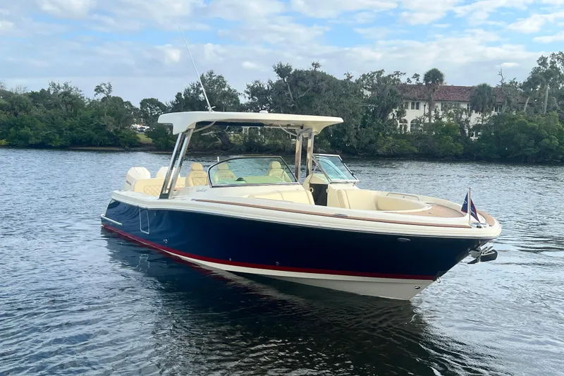Slide: The Image of 2023 Chris-Craft Calypso 30 boat on calm water, surrounded by lush greenery. - 3
