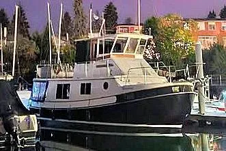The Image of 1987 Kadey-Krogen Manatee 36 yacht docked at night, illuminated by nearby lights. - 1