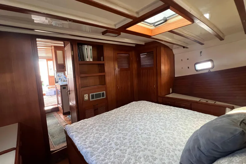 Slide: The Image of 1987 Kadey-Krogen Manatee 36 interior cabin with wood paneling and cozy bedding. - 6
