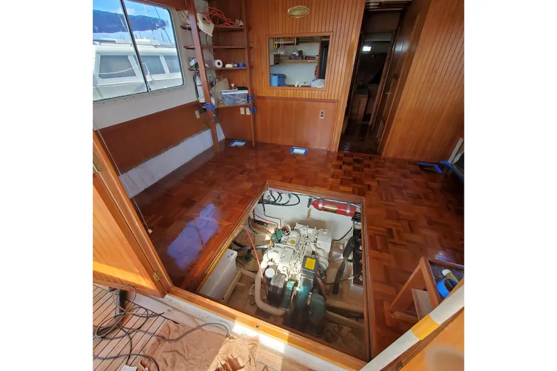 Slide: The Image of 1987 Kadey-Krogen Manatee 36 interior with engine access, wooden flooring, and nautical decor. - 10