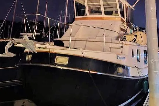 Slide: The Image of 1987 Kadey-Krogen Manatee 36 yacht docked at night, featuring a spacious cabin. - 12