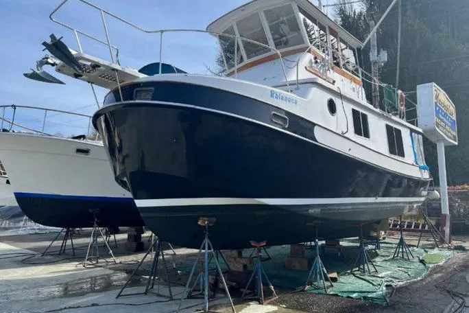 Slide: The Image of 1987 Kadey-Krogen Manatee 36 boat on stands, undergoing maintenance at a marina. - 13