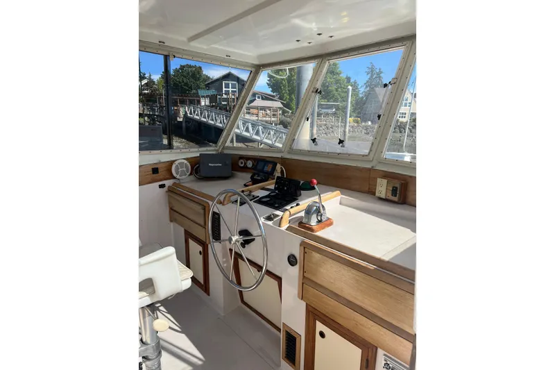 Slide: The Image of 1987 Kadey-Krogen Manatee 36 helm with steering wheel, navigation equipment, and large windows. - 7