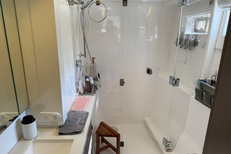 Slide: The Image of Modern bathroom in 2024 Leopard 45 yacht with glass shower and wooden stool. - 33