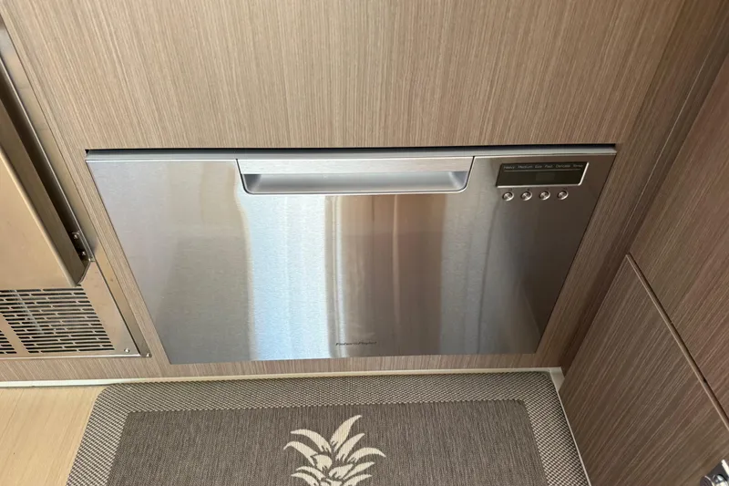 Slide: The Image of 2024 Leopard 45 interior with modern stainless steel dishwasher and wood paneling. - 38