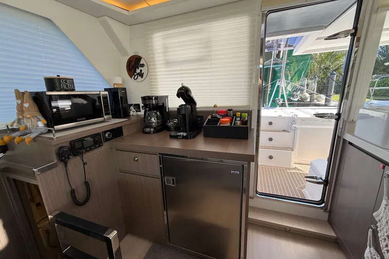 Slide: The Image of Modern kitchen area inside a 2024 Leopard 45 yacht, featuring appliances and outdoor access. - 45