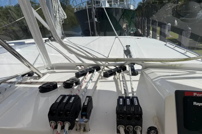 Slide: The Image of 2024 Leopard 45 yacht deck with rigging and control lines in a marina setting. - 9