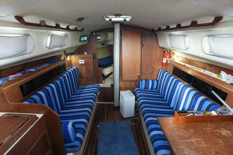 Slide: The Image of Interior of 1985 Pearson 303 sailboat with striped seating and wooden finishes. - 11