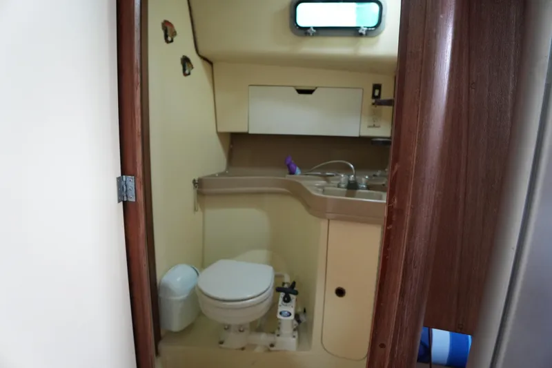 Slide: The Image of 1985 Pearson 303 sailboat bathroom with toilet, sink, and storage cabinet. - 18