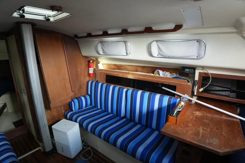 Slide: The Image of Interior of a 1985 Pearson 303 sailboat with striped seating and wooden cabinetry. - 19