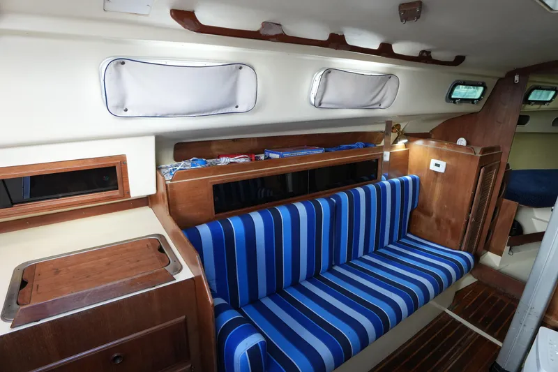 Slide: The Image of Interior of 1985 Pearson 303 sailboat with blue-striped seating and wooden accents. - 20