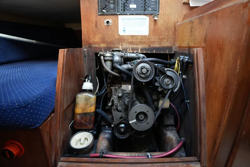 Slide: The Image of Engine compartment of a 1985 Pearson 303 sailboat, showcasing mechanical components and wiring. - 23