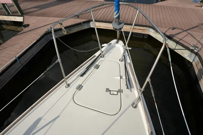 Slide: The Image of Bow of 1985 Pearson 303 sailboat docked at marina, featuring deck hatch and railing. - 5