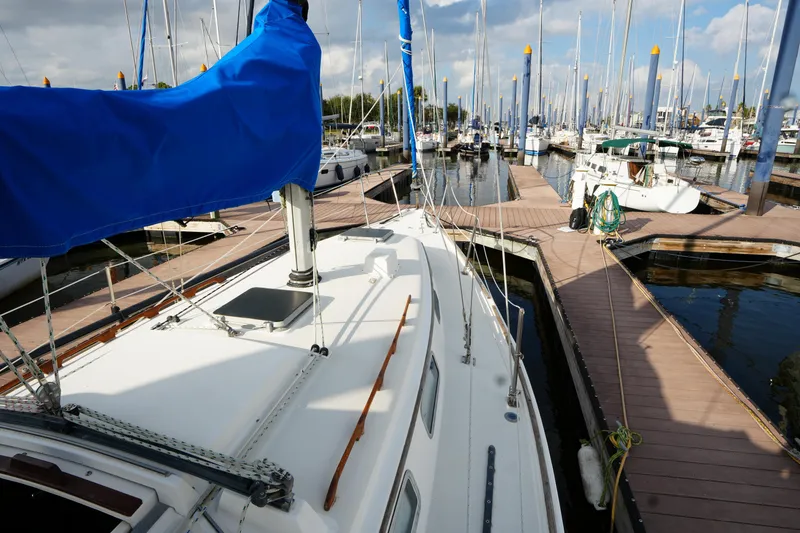 Slide: The Image of 1985 Pearson 303 sailboat docked at marina with blue sail cover. - 6