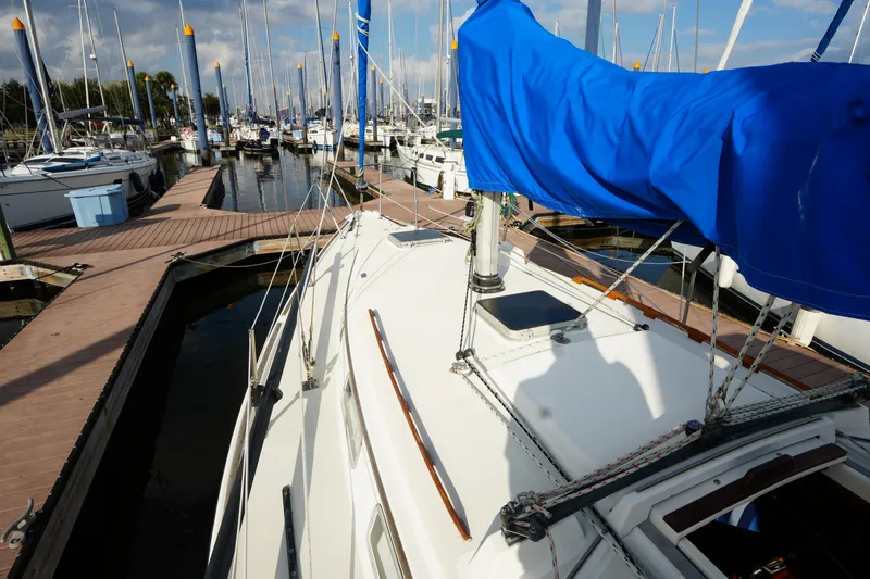 Slide: The Image of 1985 Pearson 303 sailboat docked at marina with blue sail cover. - 7
