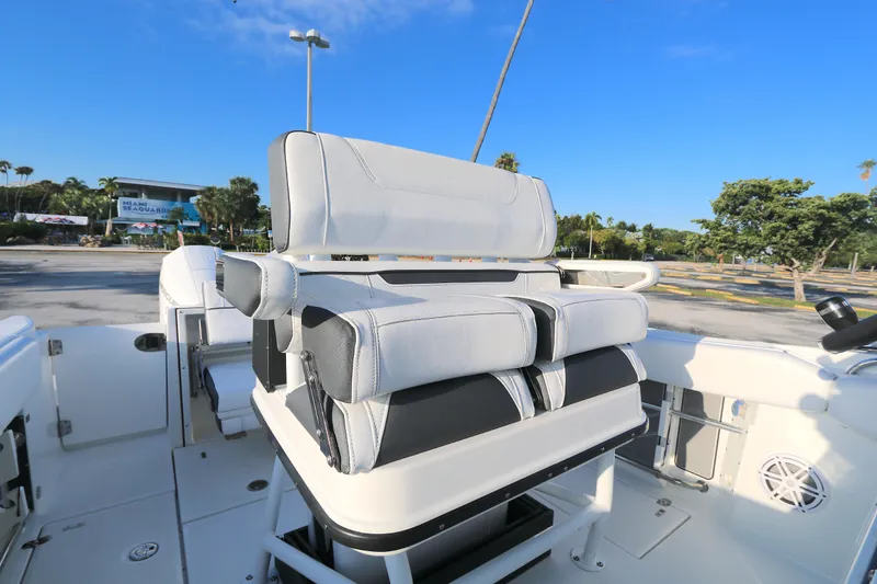 Slide: The Image of 2021 Blackfin 252 CC boat interior with cushioned seating, parked outdoors. - 3