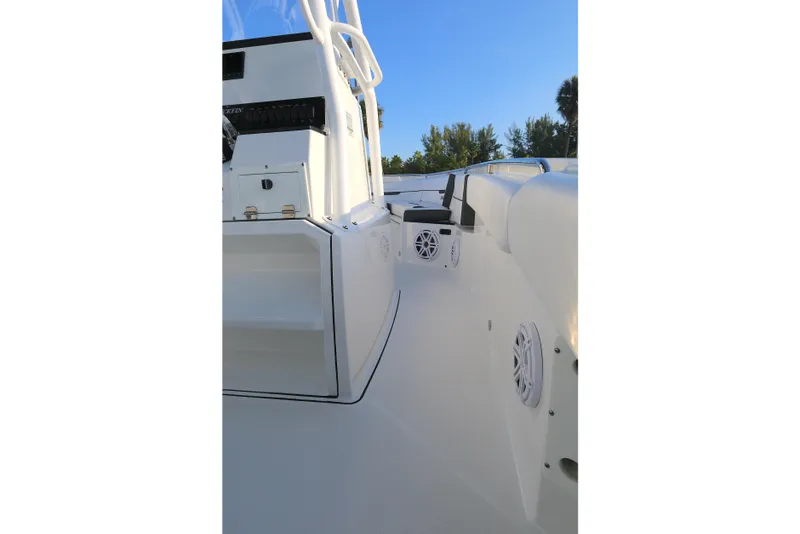 Slide: The Image of 2021 Blackfin 252 CC boat interior with speakers and console, under clear blue sky. - 4
